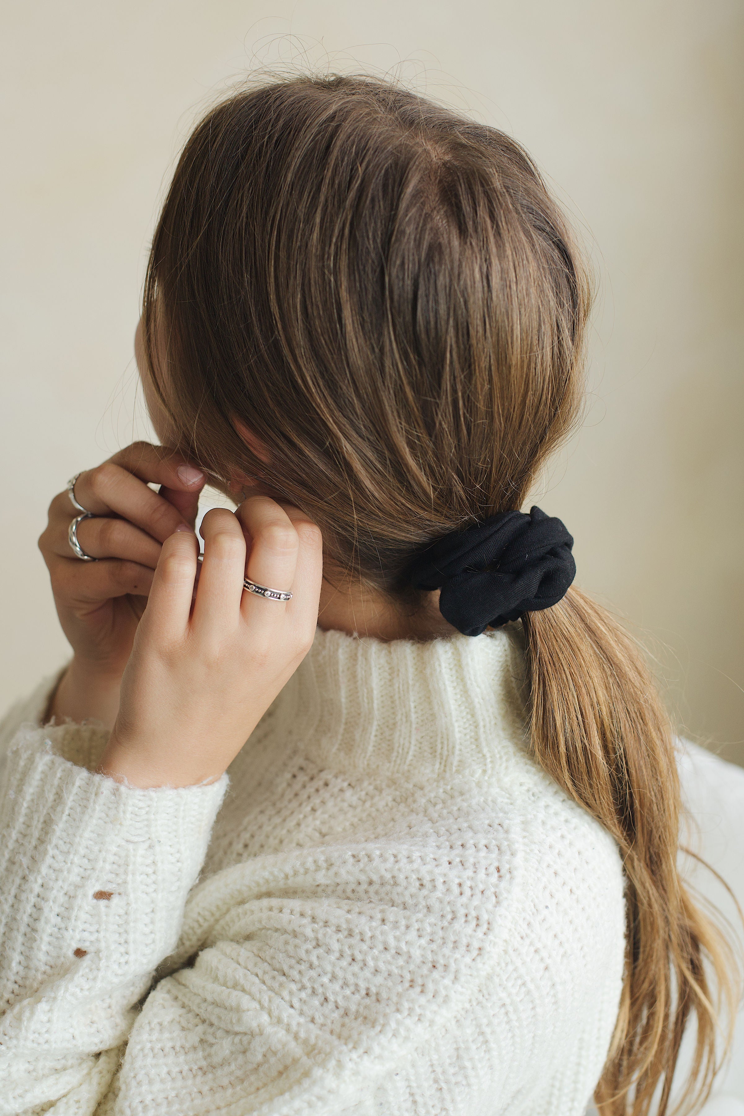 Black scrunchie in petite size in model's ponytail