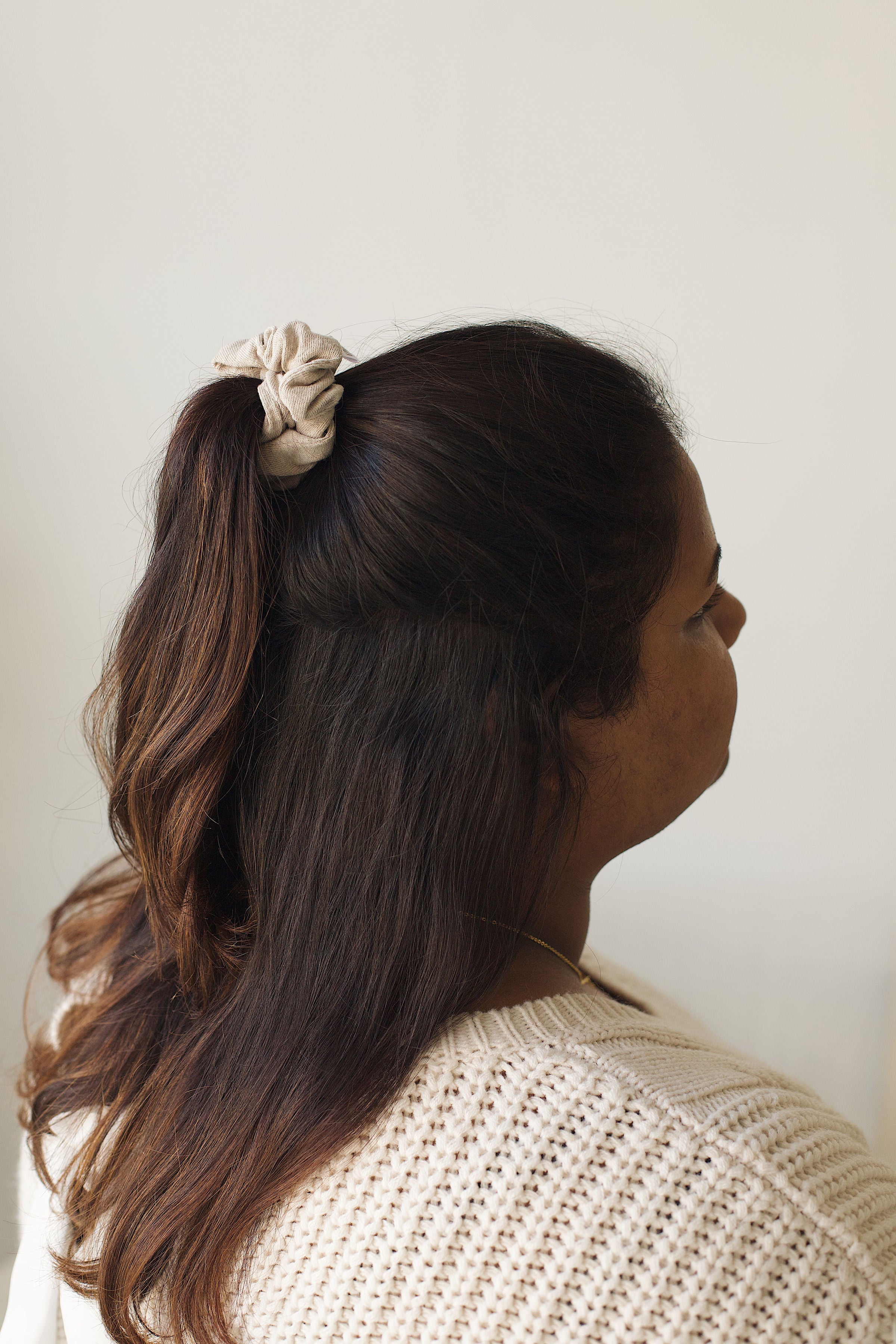 Cream Sweater scrunchie in Beau size in model's half up half down ponytail