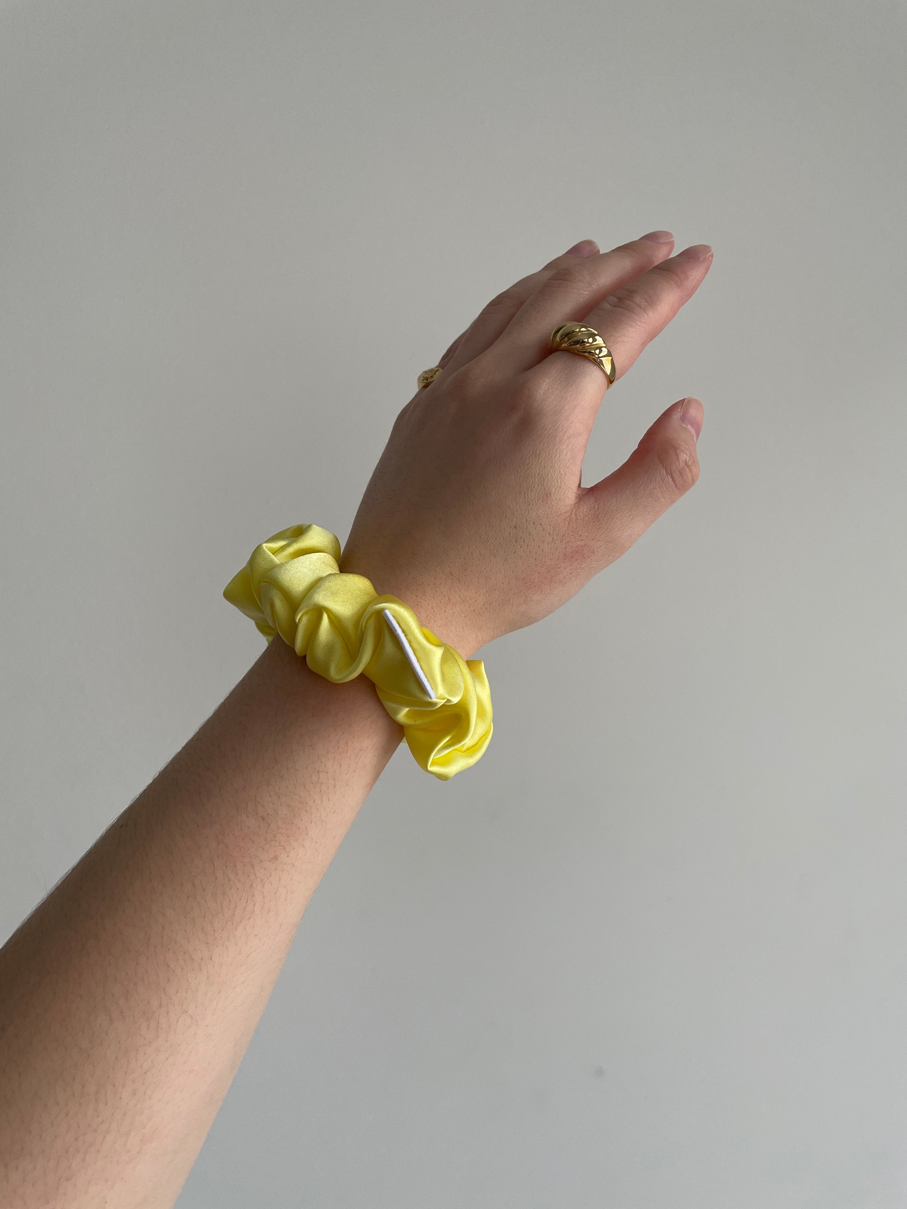 Lemon Silk Scrunchie in Beau size on woman's wrist. All scrunchies are handmade in Toronto, Canada and a tree is planted with every order.